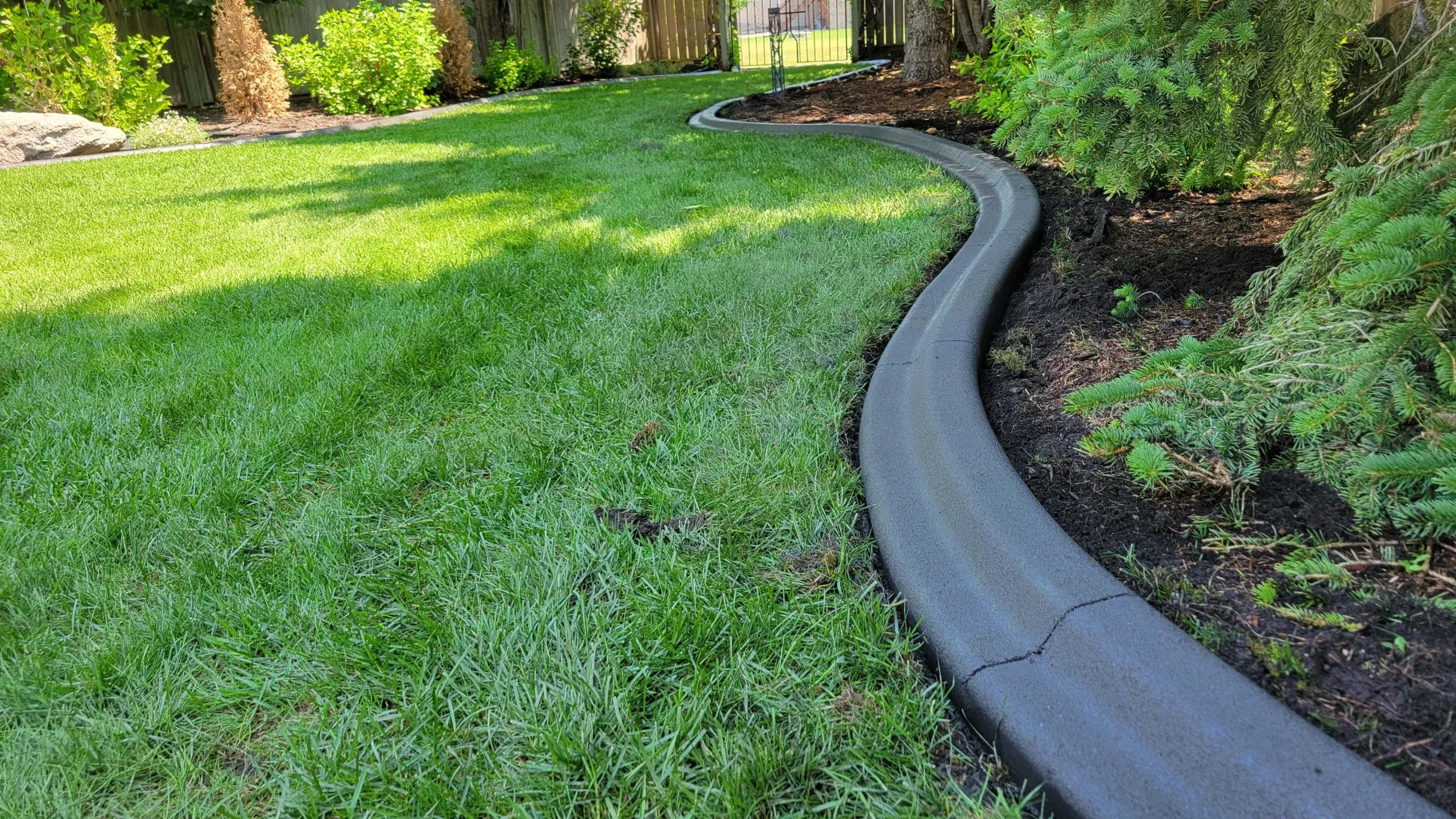 Custom hardscaping installation with stone and concrete elements featuring concrete curbing profile work for long-term bed separation in Post Falls, Coeur d'Alene, and North Idaho, gallery view 3