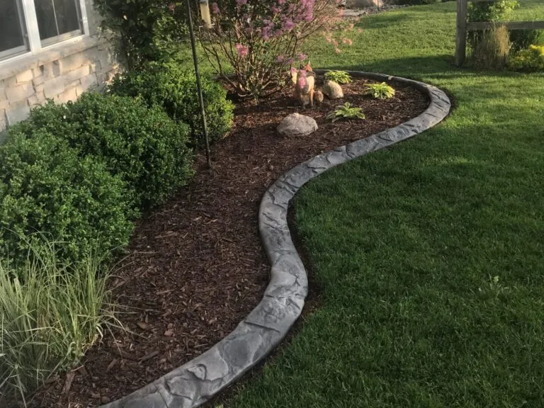 Custom hardscaping installation with stone and concrete elements featuring concrete curbing profile work for long-term bed separation in Post Falls, Coeur d'Alene, and North Idaho