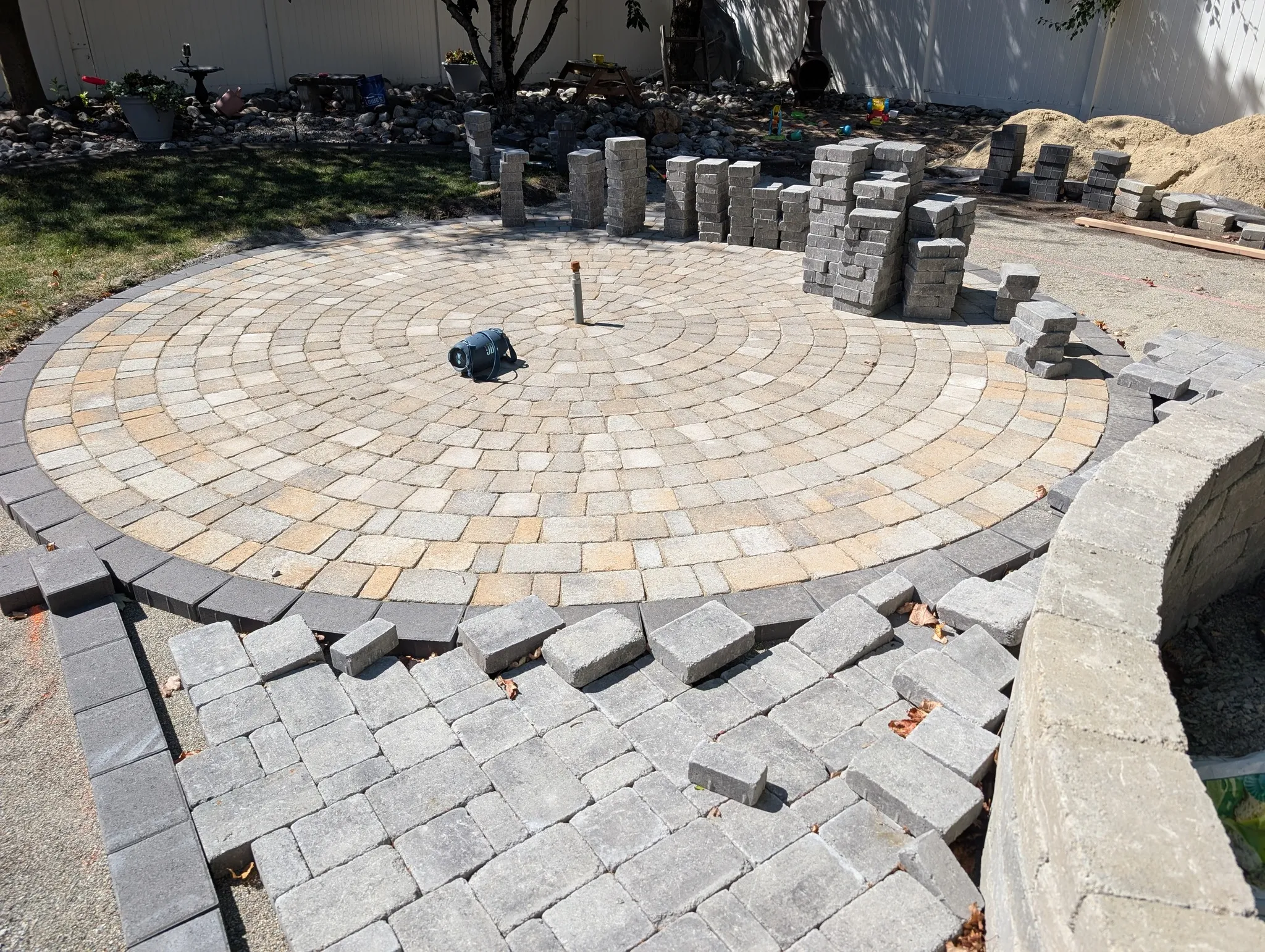 Patio and paving installation with custom stone layout and edge definition featuring material fit-and-finish supporting refined outdoor-living usability in Post Falls, Coeur d'Alene, and North Idaho