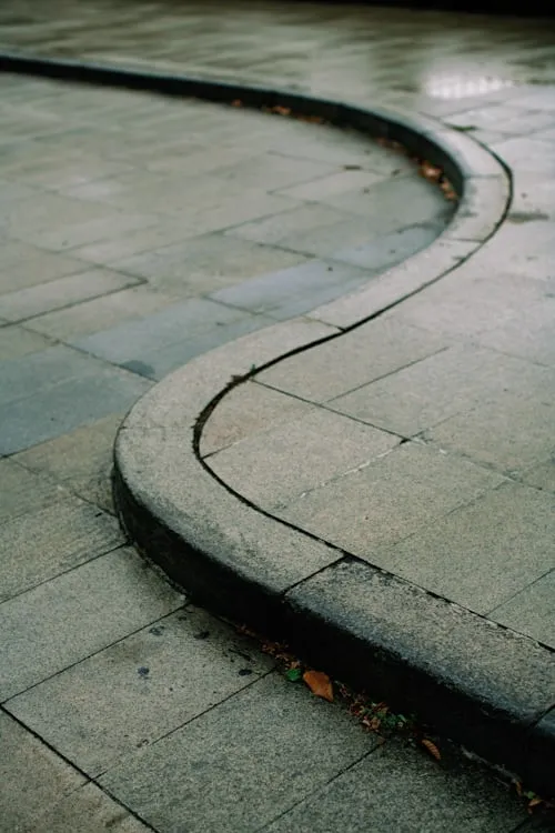 Custom hardscaping installation with stone and concrete elements featuring concrete curbing profile work for long-term bed separation in Post Falls, Coeur d'Alene, and North Idaho