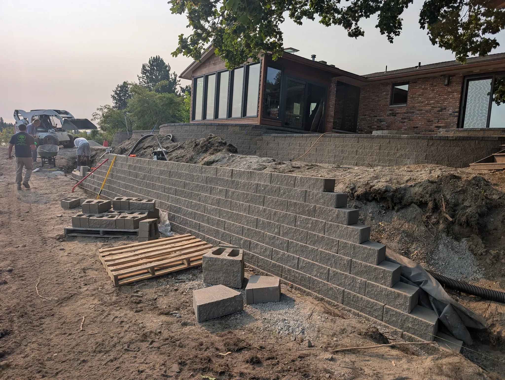 Segmental retaining wall installation with reinforced backfill and drainage featuring retaining wall alignment with base reinforcement and drainage relief in Post Falls, Coeur d'Alene, and North Idaho